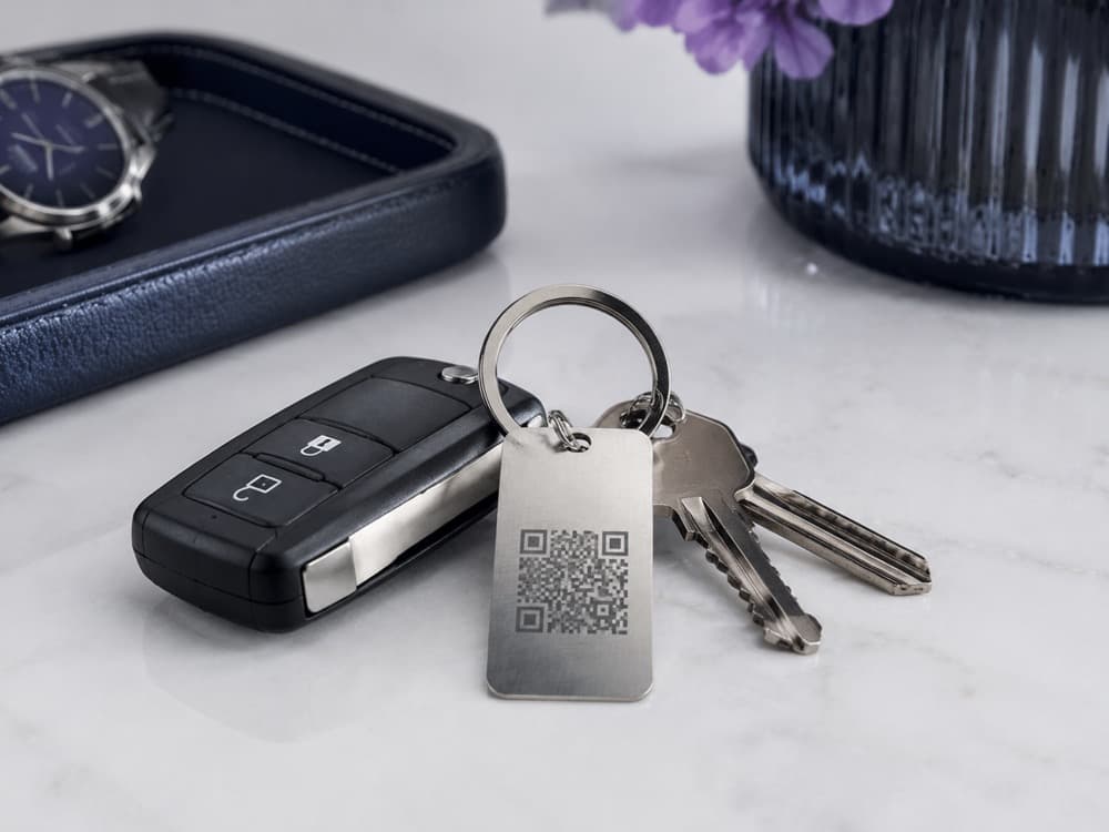 Araç anahtarı ve anahtarlara takılı QR kodlu metal ARKVIUM etiketi